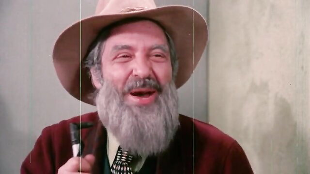 Vintage 1972 porno thumbnail: Bearded man in cowboy hat smiling with pipe