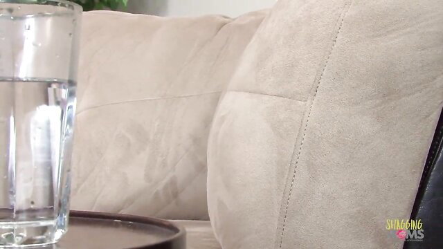 British MILF on beige couch with water glass by table