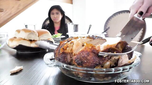 Ember Snow watches stepmom Summer Hart carve roast chicken at family dinner