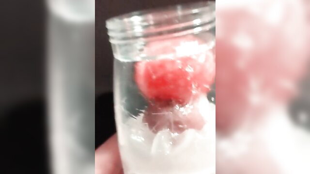 Closeup Fleshlight Quickshot cumshot on watermelon in jar, toy handjob