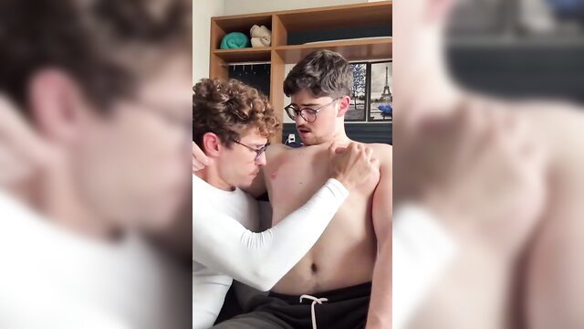 Two fit young men in intimate chest worship embrace, one shirtless