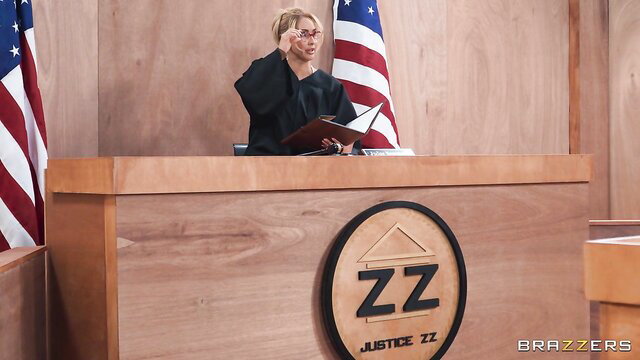 Blonde judge in black robe and glasses presides in courtroom, Brazzers