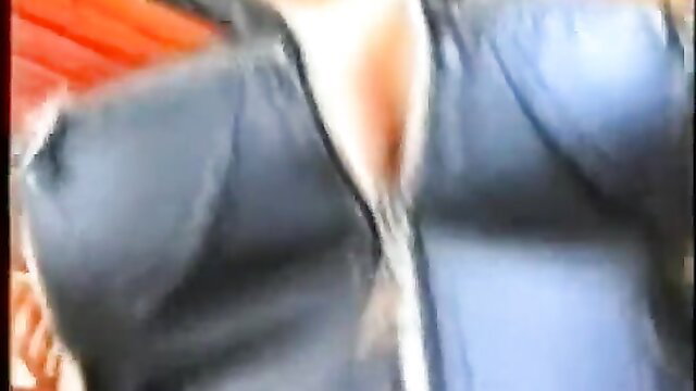 Busty Asian woman in unzipped leather jacket exposing huge tits closeup