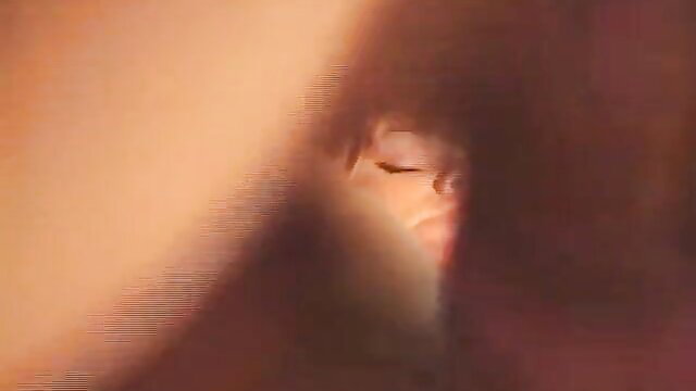 Blurry closeup of seductive Asian girl's face peeking through shadows