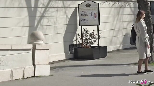 Lovely vixen in tight beige dress stands sexy outdoors by park sign