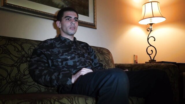 Handsome Latino guy in camo shirt sits ready for early bird blowjob