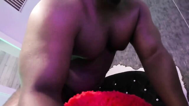 Sexy muscular black man sitting shirtless in sparkly pants