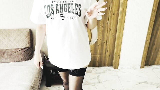 Asian MILF in LA tee and sparkly shorts poses sexy, nylons tease