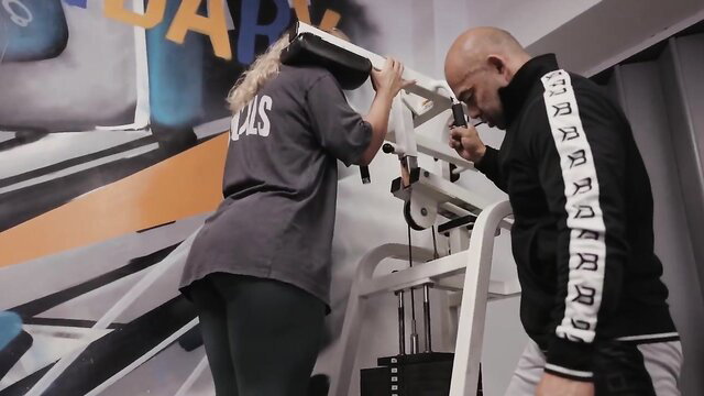 Bald male bodybuilder destroys wellness girl's legs on gym machine