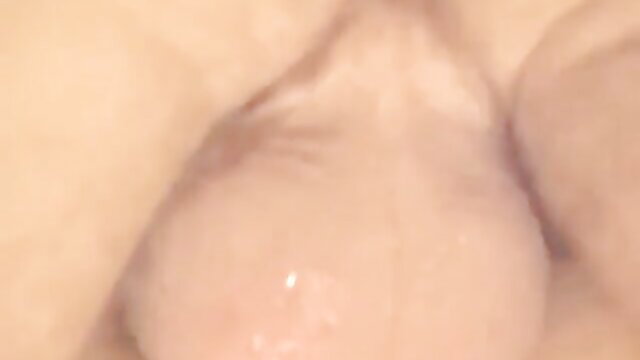 Closeup of pale woman's huge natural tits glistening with oil