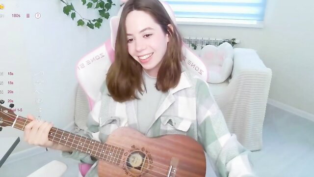 Allie Hazie playing ukulele in cute plaid outfit, smiling sweetly