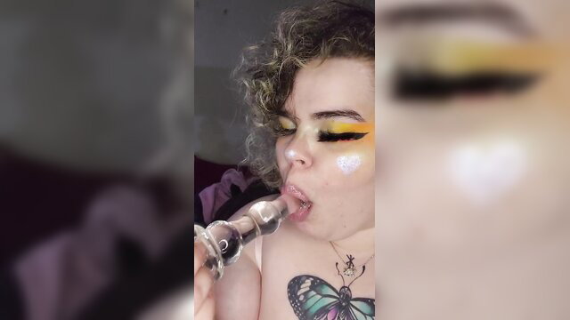 Curvy goth GF with yellow makeup sucks glass toy closeup
