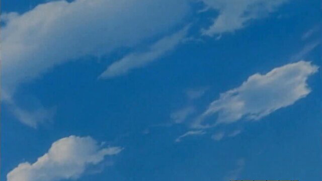 Blue sky with fluffy white clouds, serene outdoor scene