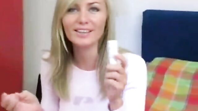 Sensual blonde babe holding big glass dildo, teasing smile