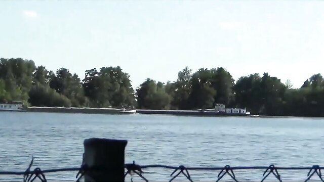 Amateur couple by scenic lake with lush trees and calm water