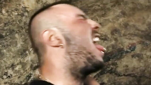 Bald bearded man screaming with tongue out in intense gooning face