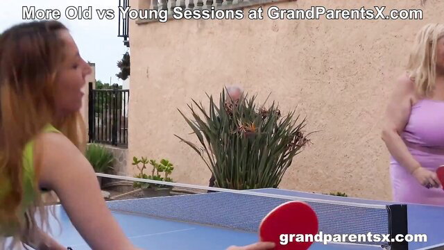 Blonde granny and stepgranddaughter in bikinis play table tennis