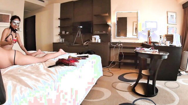 Asian beauty in thong mask lounging nude on bed solo tease