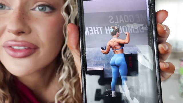 Curvy blonde holds phone showing fit girl's big ass in tight blue leggings