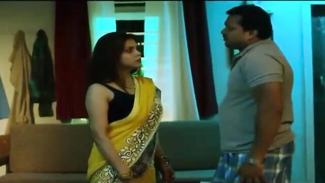 Indian wife in yellow saree chats intimately with husband in bedroom
