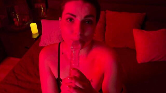 Hot brunette in lingerie giving sloppy blowjob to glass dildo closeup