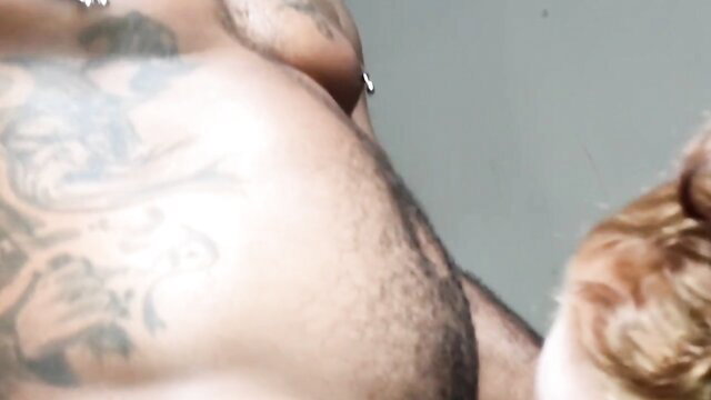Tattooed black man bulging hairy cock with redhead girl nearby