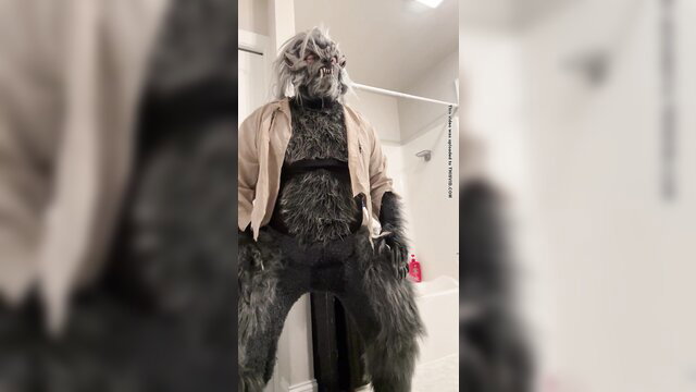 Wolfman furry in tan jacket wets himself in bathroom