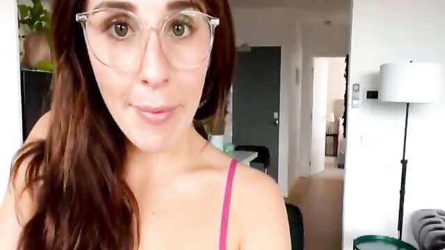 Pretty brunette in pink camisole strap smiling at camera, teasing disrobe