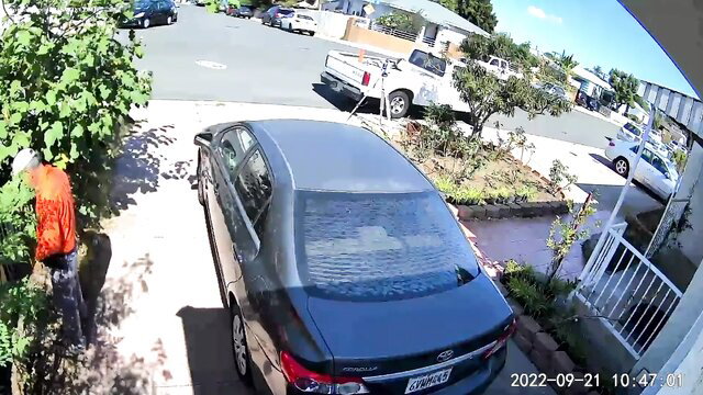 Orange-clad surveyor worker pissing on driveway in outdoor amateur video