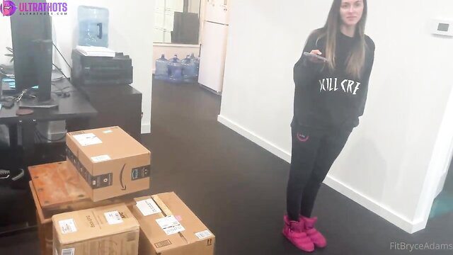 Bryce Adams in tight leggings and hoodie by Amazon boxes office