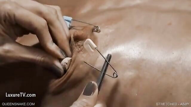 Abby in Queensnake Stretched: pussy stretched with safety pins closeup