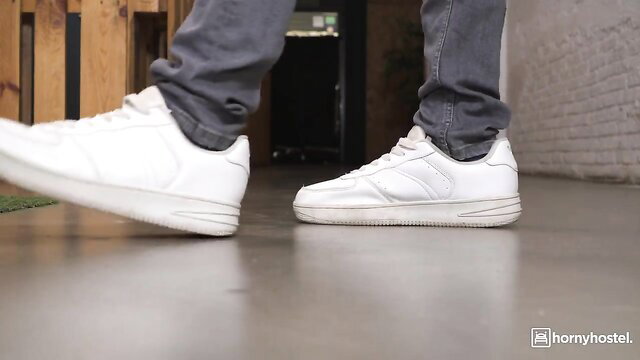 Brunette beauty in tight gray jeans and white sneakers teasing legs