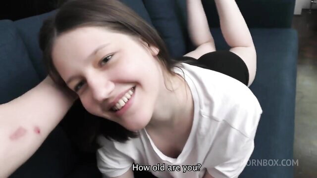 Margo von Teese smiles playfully on couch in tight top and shorts