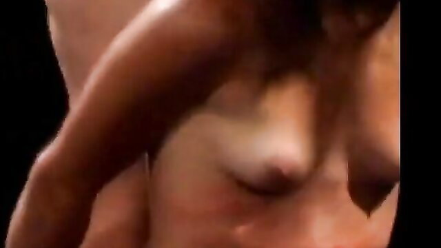 Closeup of dark-skinned lesbian's breasts in torturous game