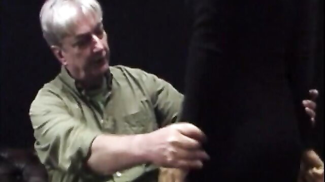 Mature man spanking young woman over knee in discipline scene