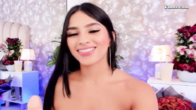 Cute Latina babe smiles holding dildo topless in solo play