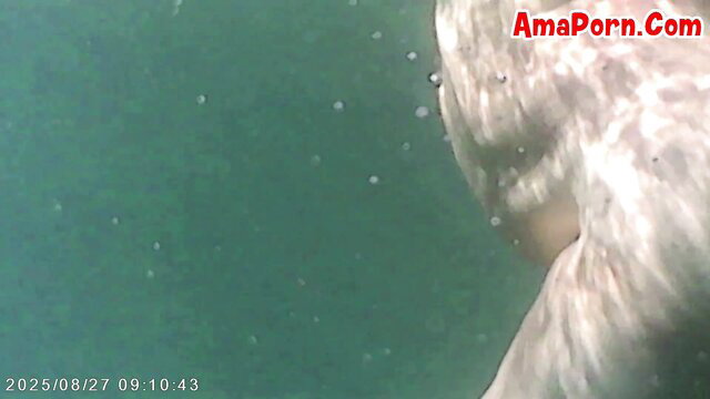 Nude woman underwater, pale skin curves and ass visible in pool