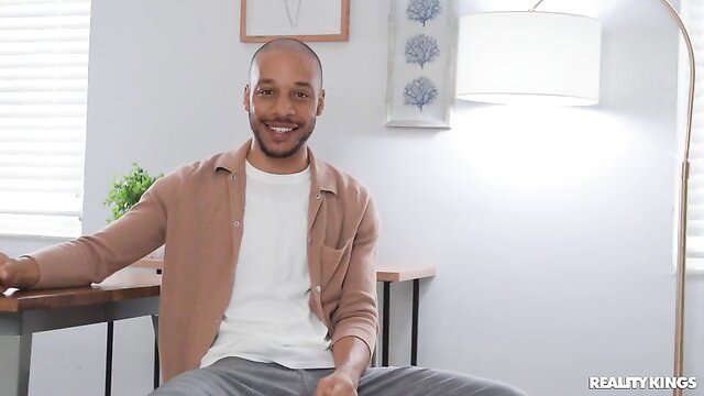 Handsome bald Black man in open shirt smiling on Reality Kings