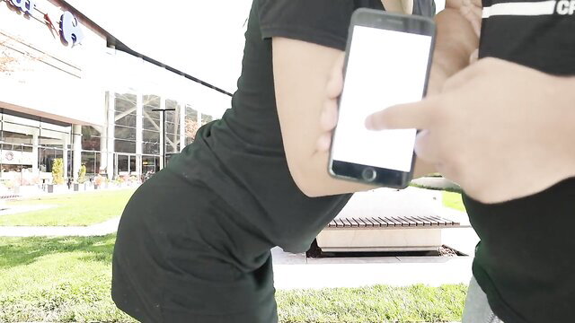 Hot Asian babe in tight black dress teased by guy with phone vibrator on mall terrace