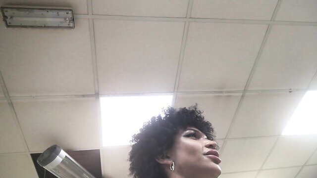 Afro femboy Bambiii looks up outdoors, lips parted seductively