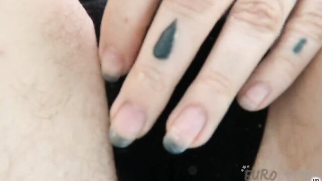 Closeup of woman's tattooed fingers on thigh in wild solo tease