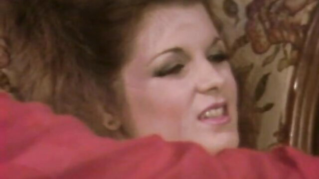 Brunette with heavy makeup in red dress from 1983 vintage porno The Personal Touch