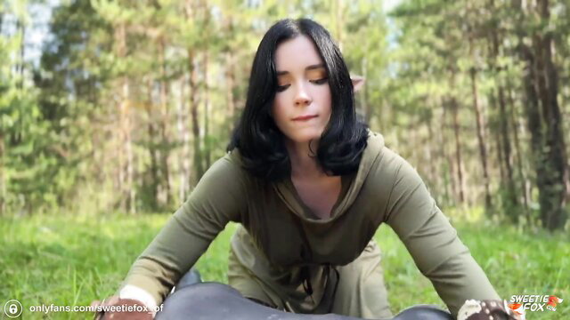 Brunette elf-eared beauty in green hoodie meditates in forest VR tease