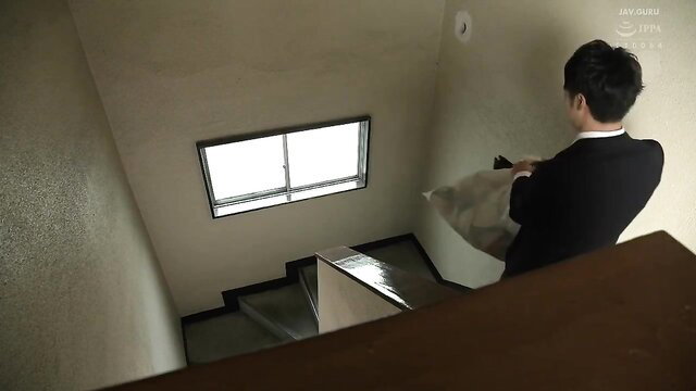 Mio Kimijima in suit holding pillow on stairs, Wife Next Door JAV