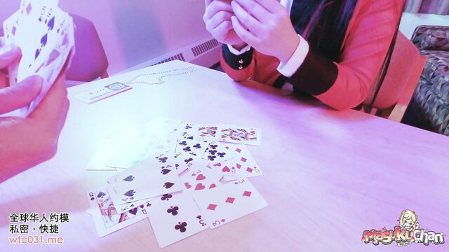 Yumeko Jabami cosplay girl in red dress holds cards at table, pink glow