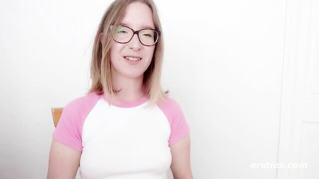 Petite Amelia in pink crop top smiles teasingly at camera