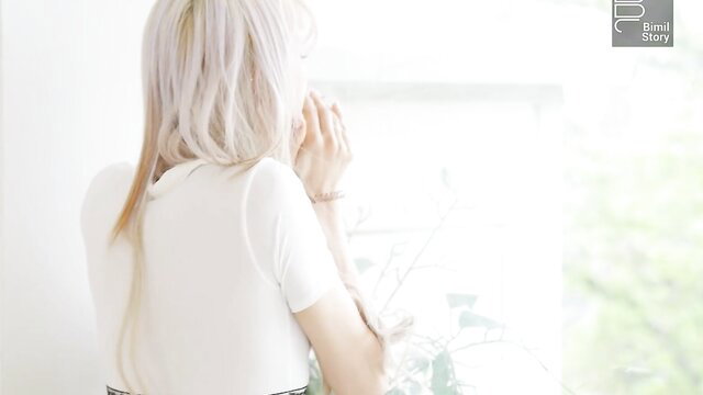 Pale blonde Taeri cosplay girl in white tee gazing out window