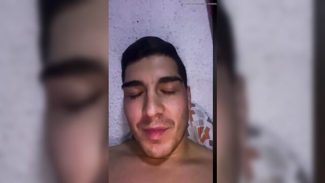 Handsome young Chilean guy shirtless closeup, lying back seductively