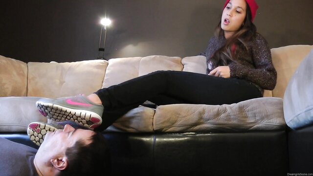Celestia in red beanie uses guy's face as footstool in grey Nike sneakers