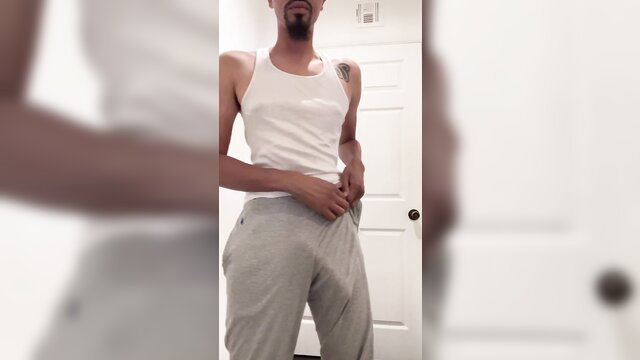 Muscular black guy in tight gray sweatpants bulging cock, white tank top tease